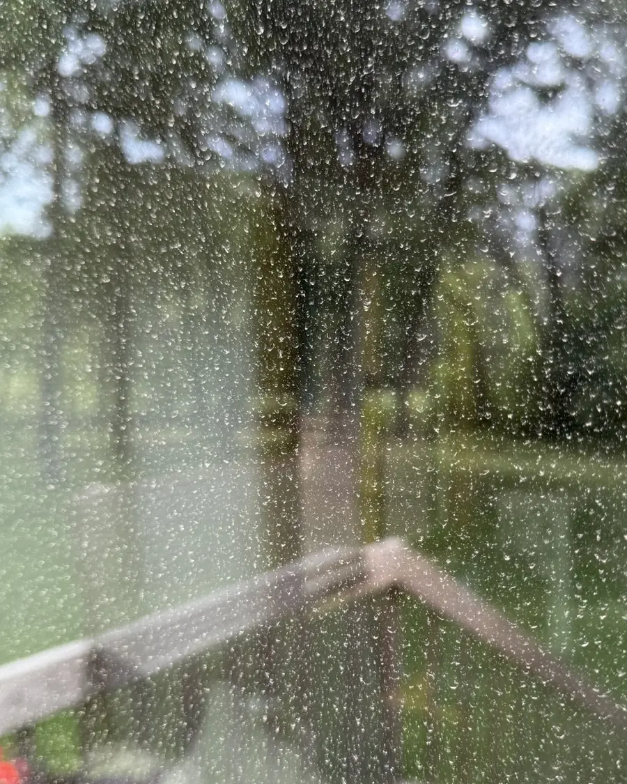 Patio door glass covered in water spots, obscuring the view of the deck